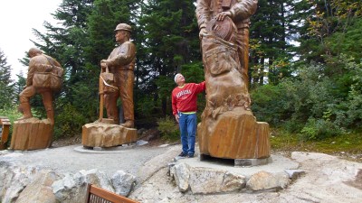 Les admires the wood carvings on Grouse Mountain